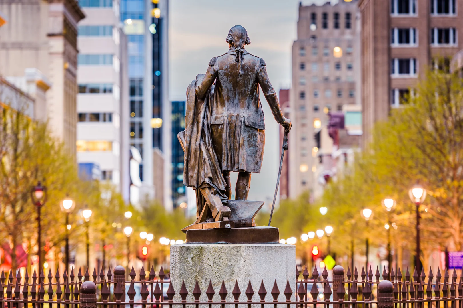 Downtown Raleigh streetscape centered on a civic statue